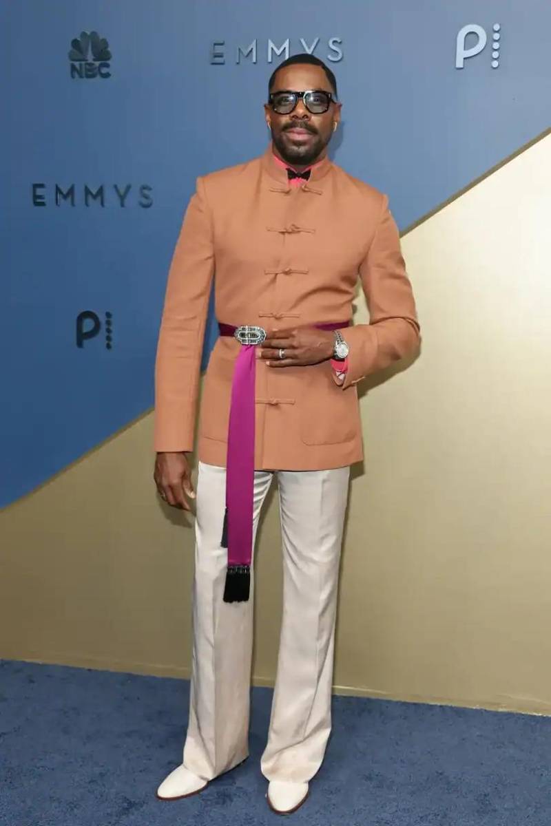 Colman Domingo apostó por el color con una chaqueta cobre de cuello mandarín,pantalón crema y una banda magenta a la cintura, todo de Valentino.