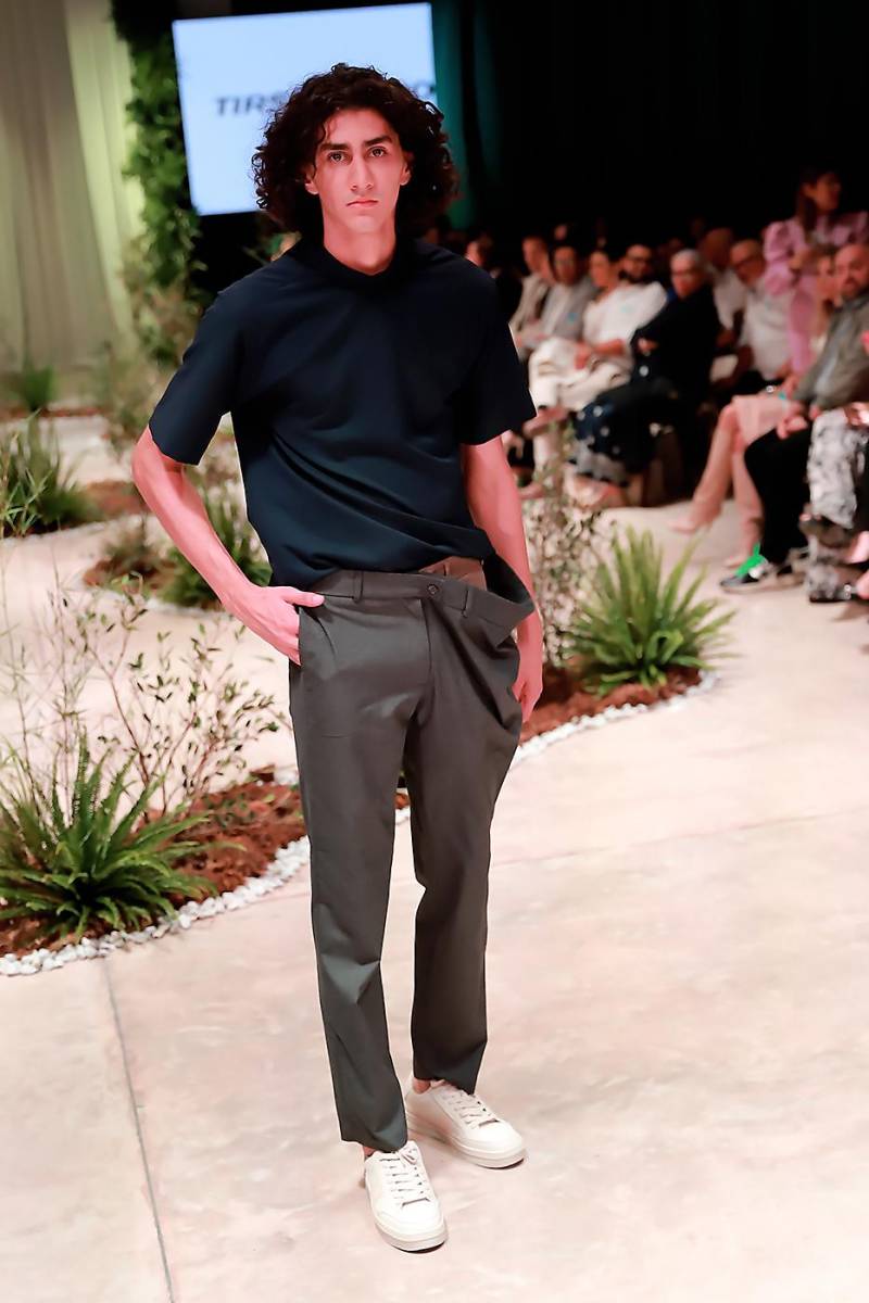 Slim pants de corte moderno se llevan con camisas en tonos contrastantes para un efecto de elegancia urbana 