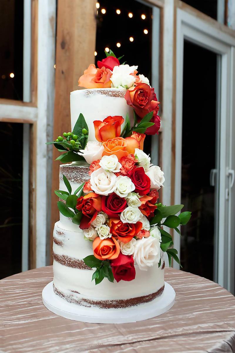 Pastel de bodas de tres niveles adornado con rosas.