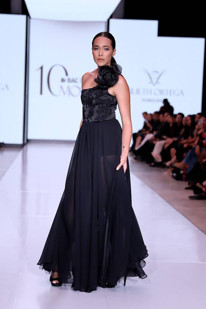 Cada una de las piezas reflejo fragmento de la novelista hondureña. Vestido de gala negro con bordado y escote, flor central y falda amplia de chiffon y mesh, evocando luto, nostalgia y la fuerza silenciosa de Blanca Olmedo, cierre de su historia y símbolo de melancolía y belleza que trasciende el dolor.