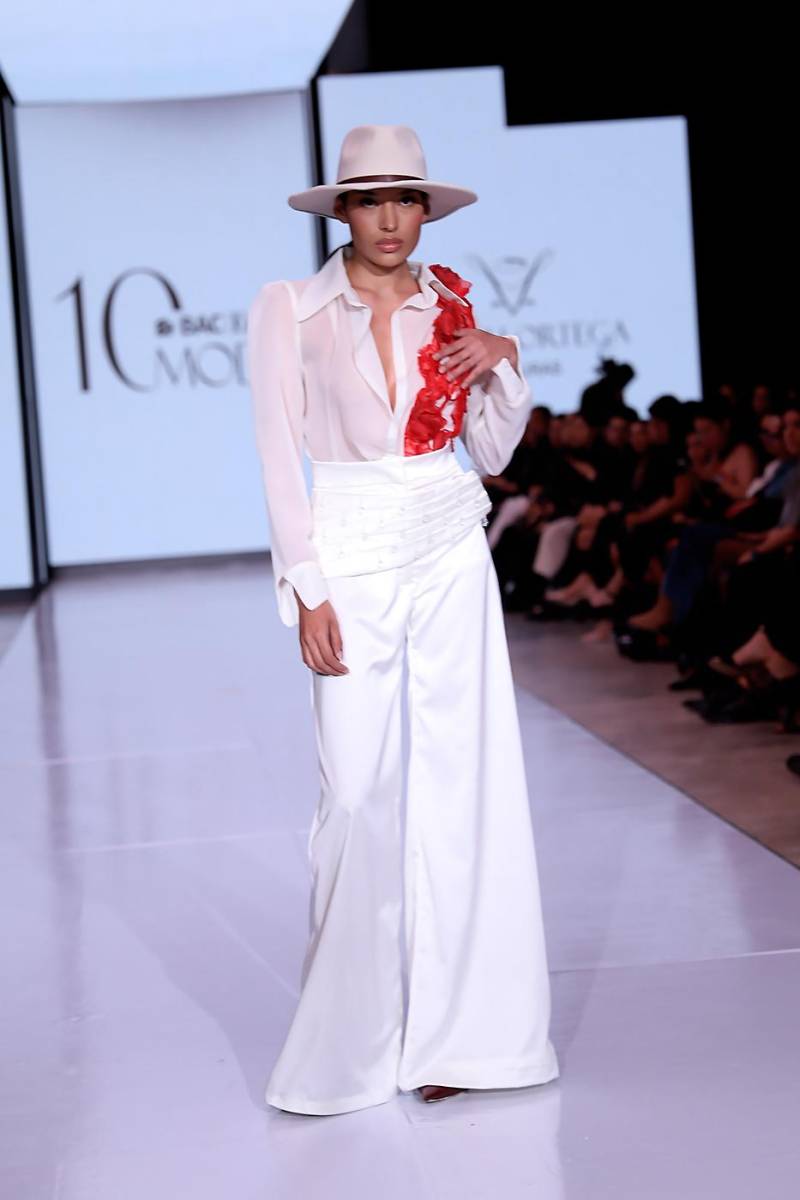 Conjunto blanco de pantalón amplio y blusa de manga larga, con bordado artesanal de flores rojas y cristales sobre organza en cascada, simbolizando la firmeza de Blanca y el dolor de la pérdida de Gustavo