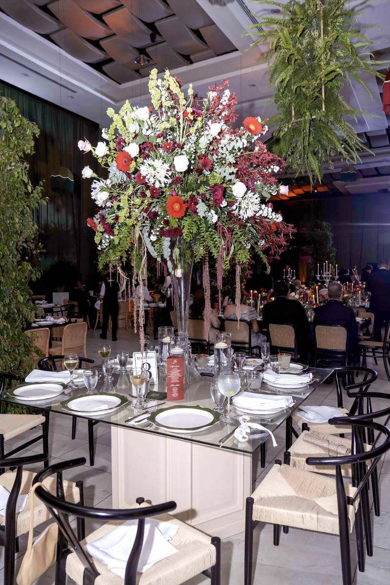 Arreglos altos sobre bases de vidrio sirvieron como centros de mesa, elaborados por los expertos de Floral Boutique.