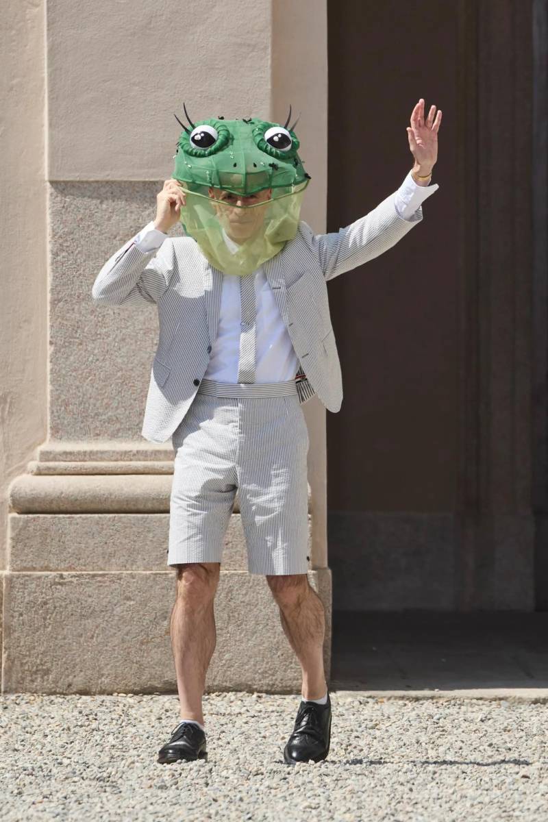 El desfile cerró con una sorpresa: el mismísimo Thom Browne salió para saludar a su público, luciendo un casco que simulaba la cabeza de un sapo.
