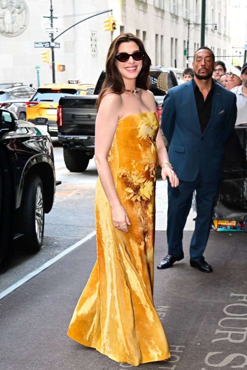 En un evento de prensa, Hathaway lució un vestido amarillo brillante con un llamativo estampado floral de Lela Rose, que acompañó con unas sandalias de Gianvito Rossi, joyas de Bulgari y unas gafas de sol de Krewe