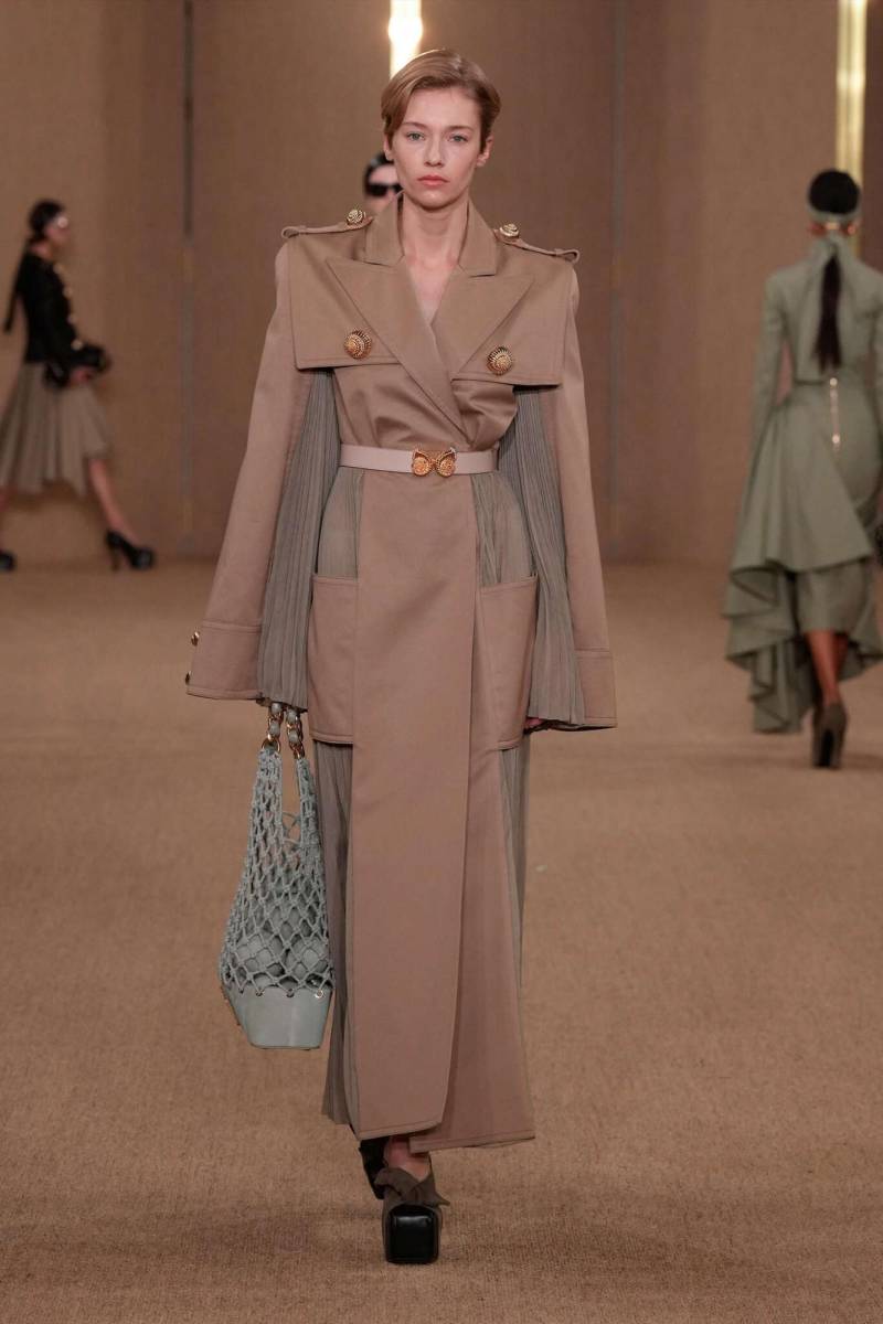 La gabardina, de origen militar adopta detalles plisados y se transforma en un vestido tipo kimono con hombreras y chaquetas recortadas con capucha en una paleta de tonos tierra. 