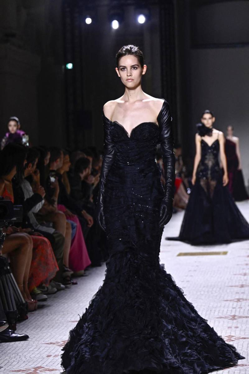 Vestido de escote corazón con guantes que emulan mangas ajustadas hasta el hombro y delicada falda con bordados de lentejuelas que termina en mini ruffles