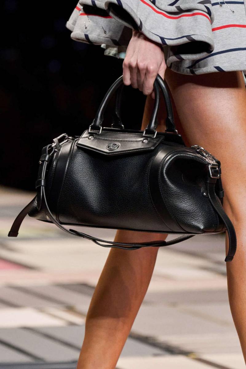Este moderno diseño de este a oeste presenta asas superiores ligeramente alargadas, una correa para el hombro ajustable y desmontable. Confeccionado en cuero granulado con detalles en cuero liso, el bolso presenta una sutil holgura que contrasta con sus prominentes herrajes de estilo motero. 