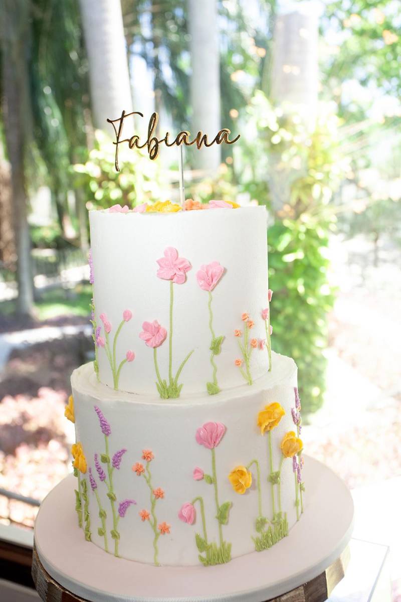 El pastel de dos niveles de mantequilla con detalles florales en su capa.