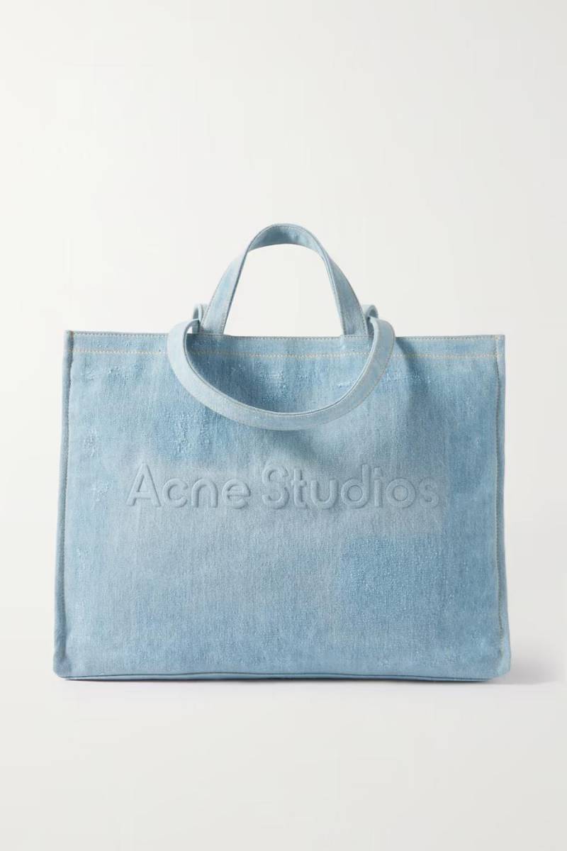El bolso tote de Acne Studios resume a la perfección la estética poco convencional de la marca. Está confeccionado en denim desgastado con el logo de la marca grabado en la parte delantera. En el interior encontrarás un pequeño bolsillo para tarjetas y llaves.