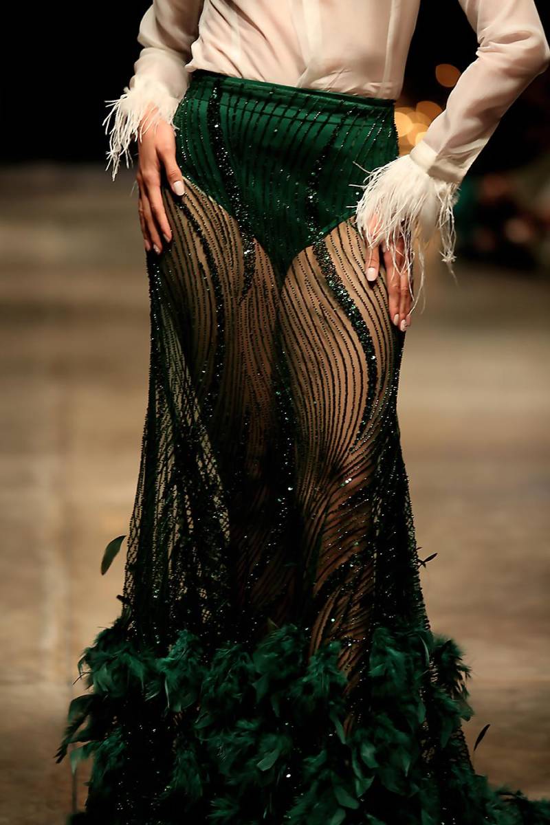 Camisa de gazar de seda y falda de transparencia con bordados de lentejuelas y brillo y plumas de avestruz aplicadas a mano.