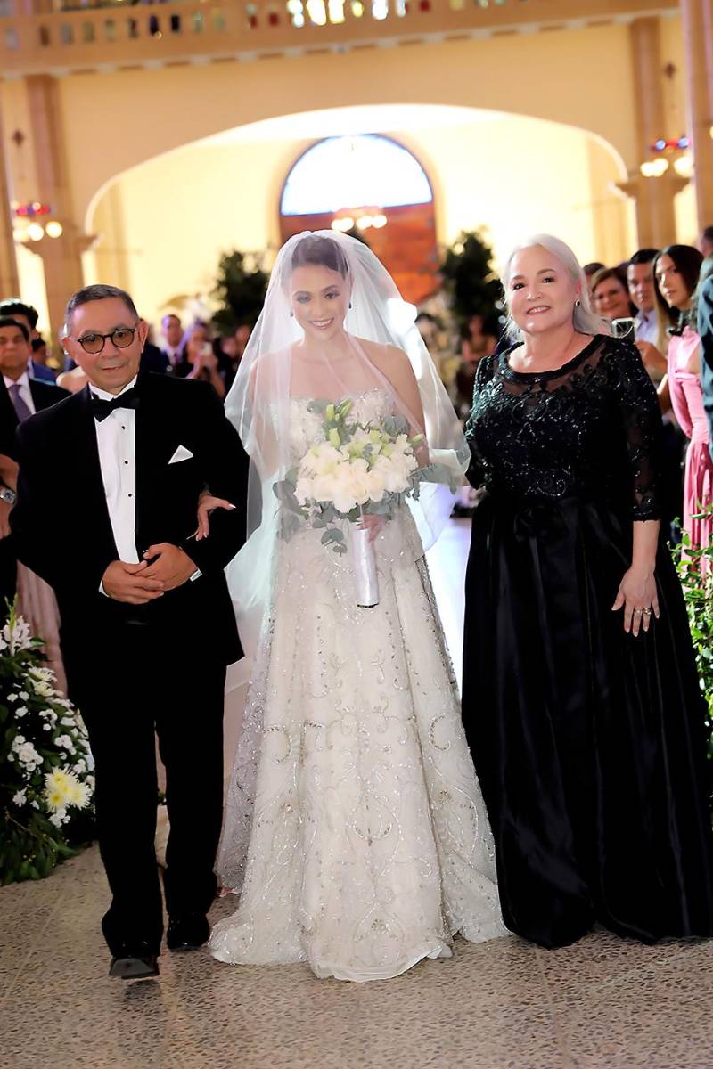 LA novia al momento de entrar con sus progenitores: Sergio y Arlene Vélez