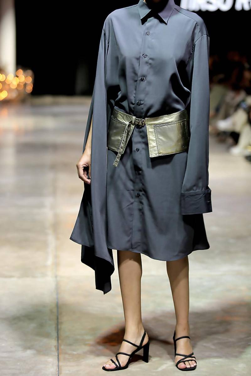 Vestido camisero en gris, color insigne de la apuesta, que se contrasta con detalles como este cinturón superpuesto de bolsillos en plateado.