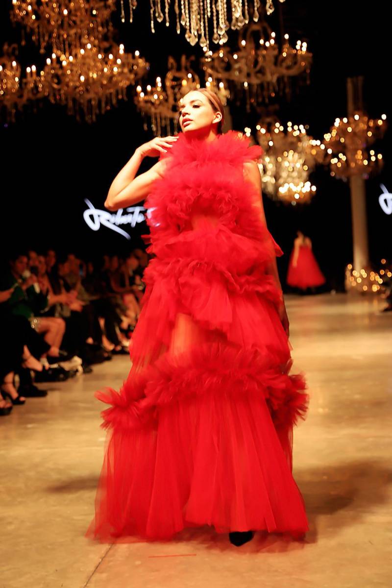 Vestido de cuello halter y falda peplum en dos tiempos, confeccionado en vaporoso tul, es una de las piezas más teatrales e imponentes de la apuesta