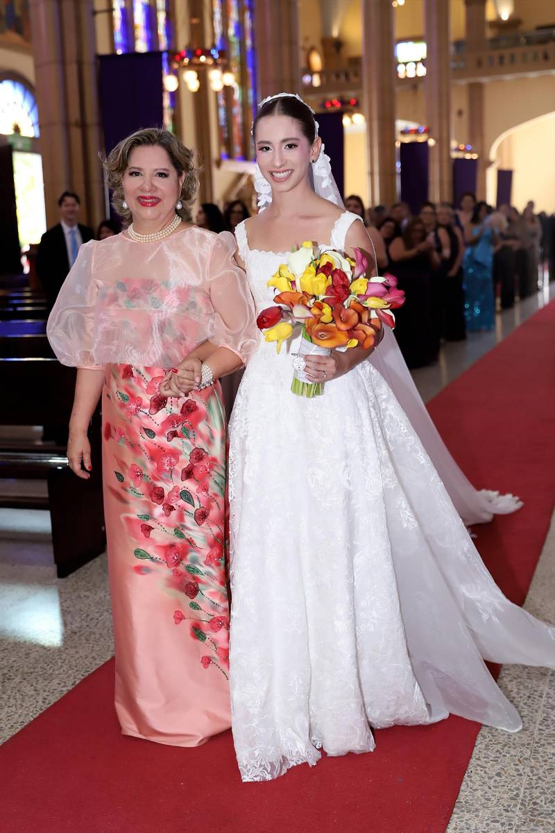 La feliz novia del brazo de su orgullosa madre Dinorah 