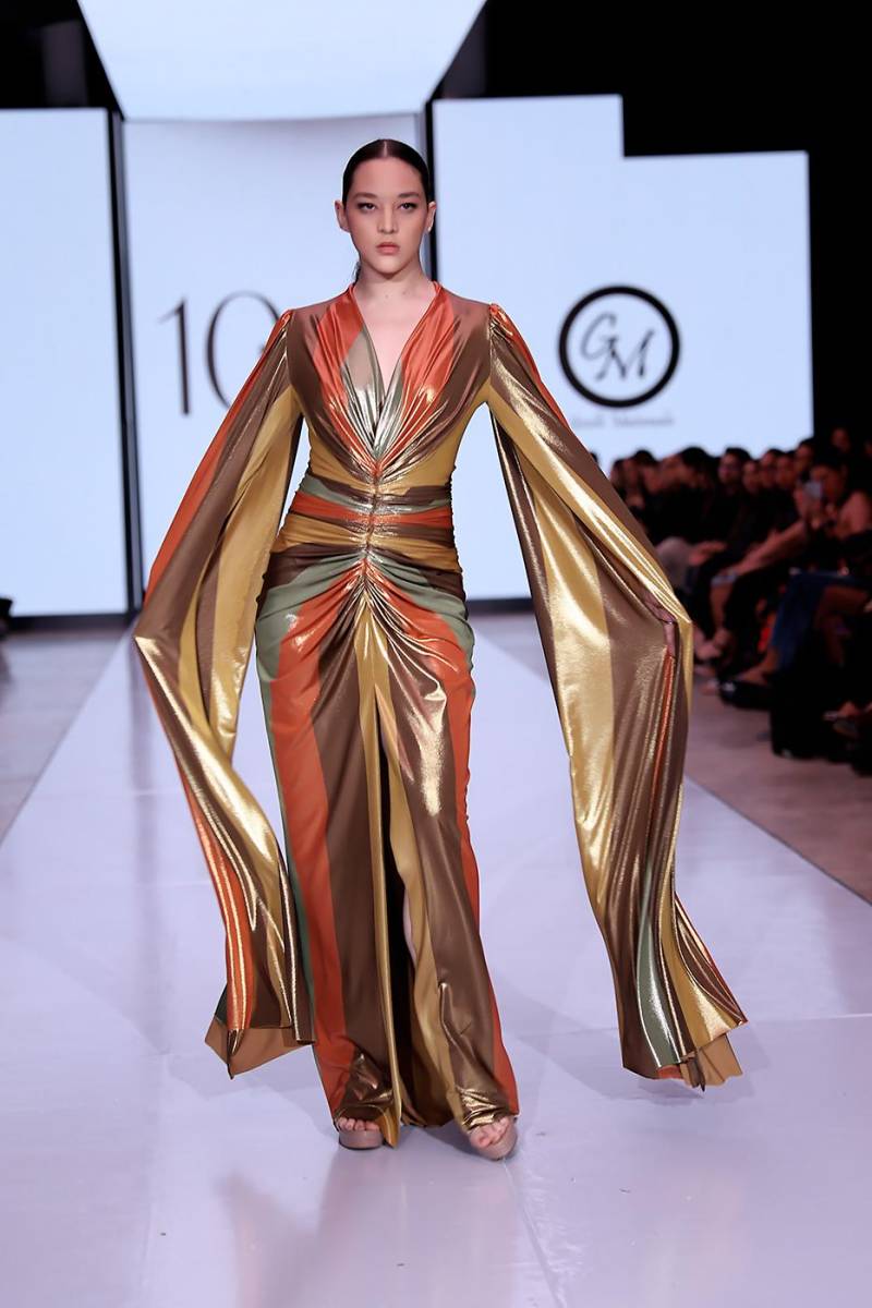Los tonos desérticos y un toque suntuoso y femenino definen este vestido de mangas dramáticas para la reina de las fiestas