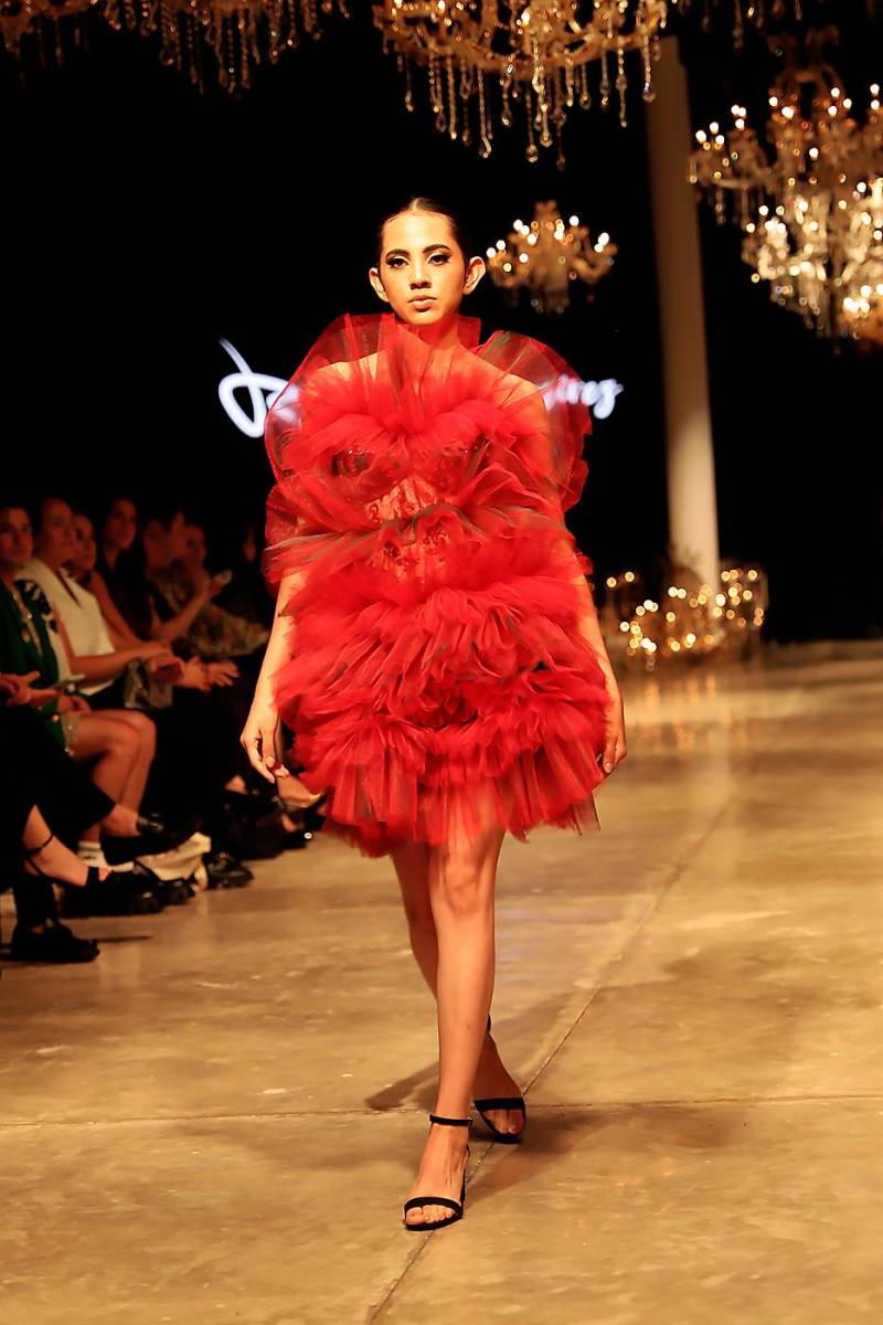 El volumen y el drama que Roberto Ramírez imprime en sus colecciones no podía faltar esta vez en la que juega con ruffles de tul superpuestos en vestidos midi