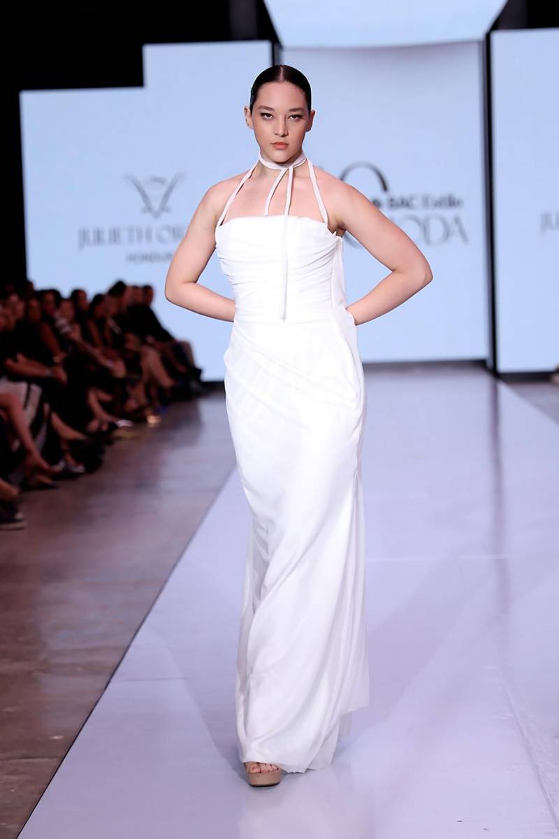 Vestido largo blanco con drapeado en mesh que abraza el torso y fluye hasta el suelo, simbolizando la pureza y delicadeza de Blanca Olmedo, etérea y luminosa en cada pliegue