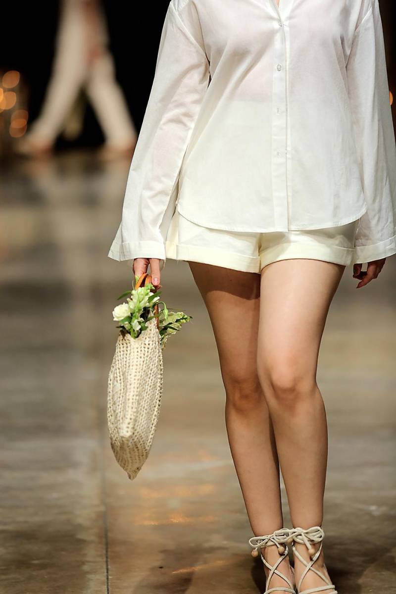 White button down shirt de silueta amplia con shorts de dobladillo y bolso tejido a mano.