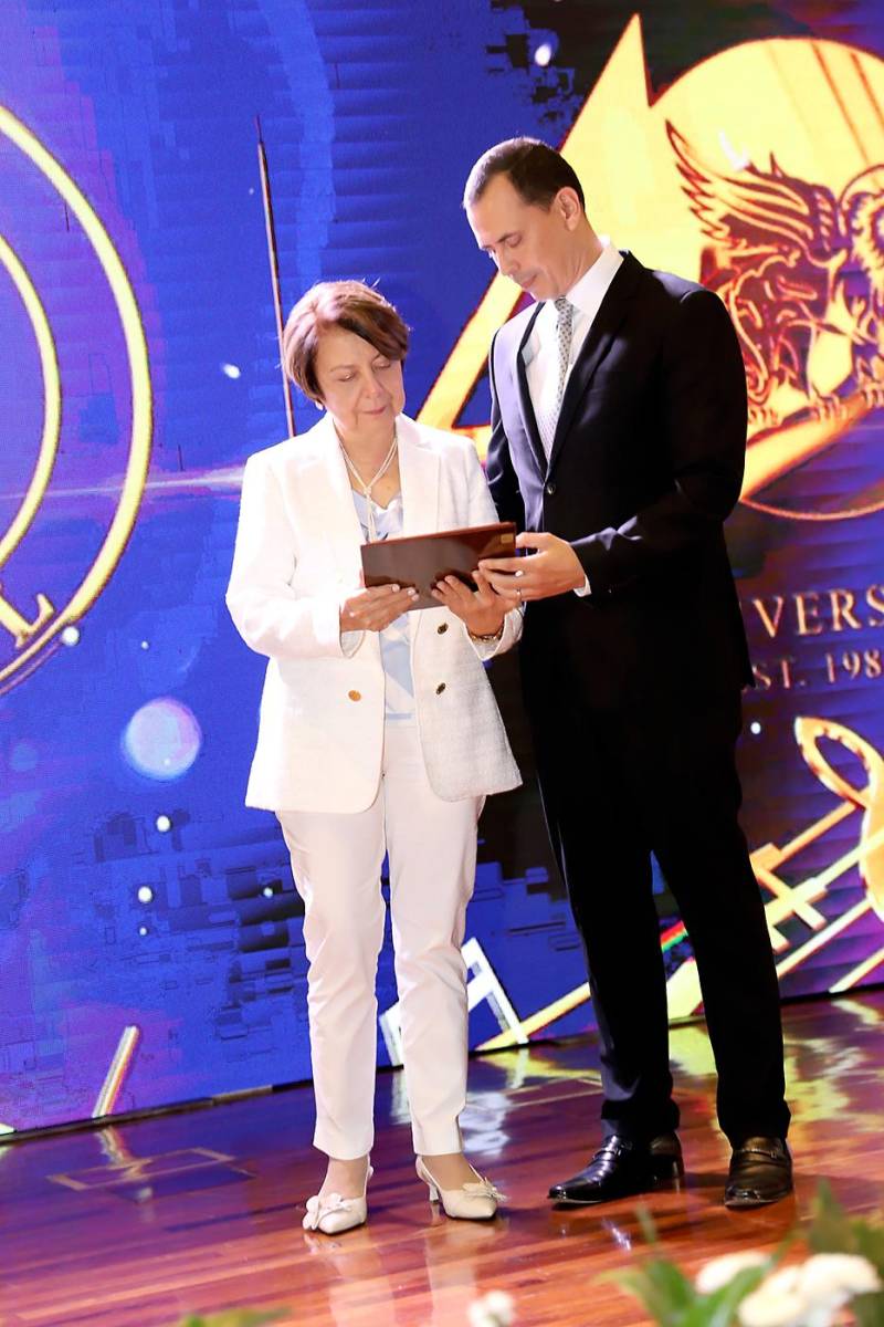 Ana Rubiano-Merriam recibe el reconocimiento de manos de su hijo, Ruy Merriam