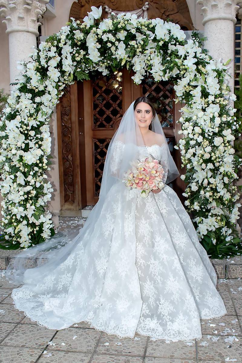 Fabiola Larach, luce su delicado vestido de novia estilo strapless, manga de medio brazo y falda amplia con su delicado velo.