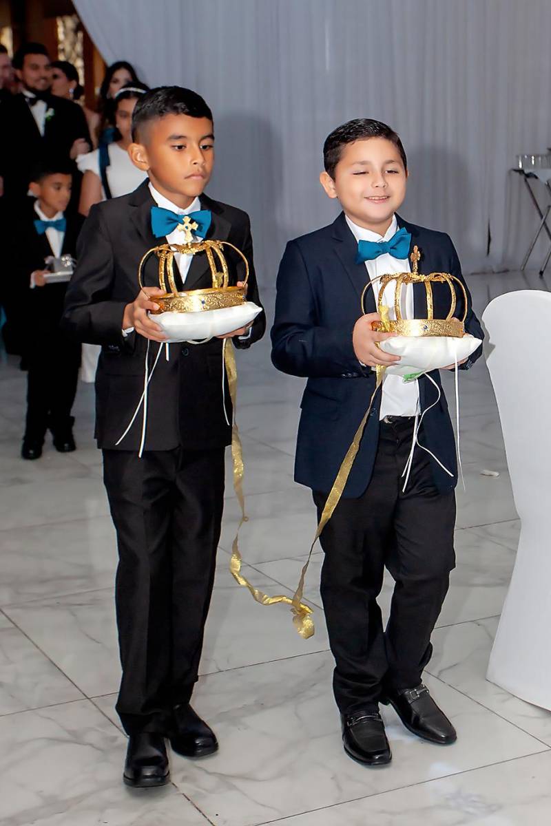 Los niños cargan las coronas de los novios.
