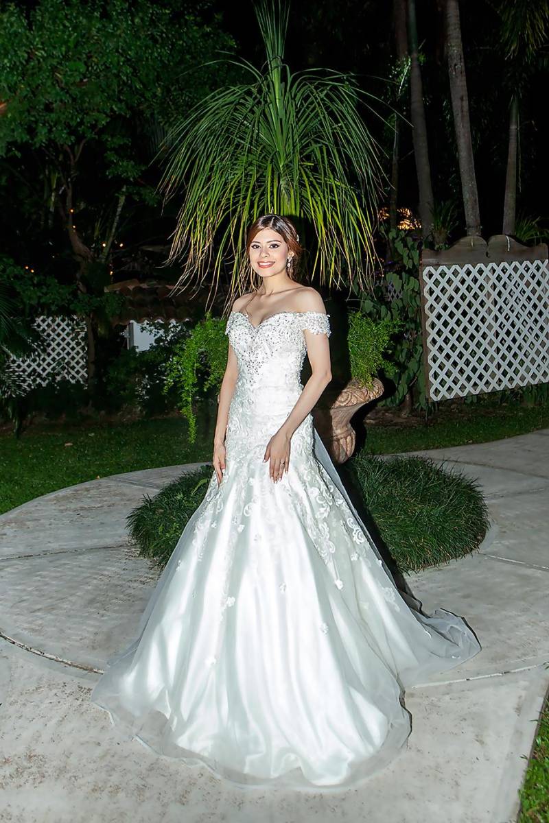 La novia María Gabriela Castro Flores ataviada en un vestido Bride’s Gallery en corte trompeta off shoulders.