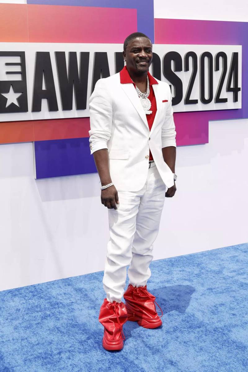 El rapero Akon lució un traje blanco, dándole un pop de color con zapatos y camisa roja.