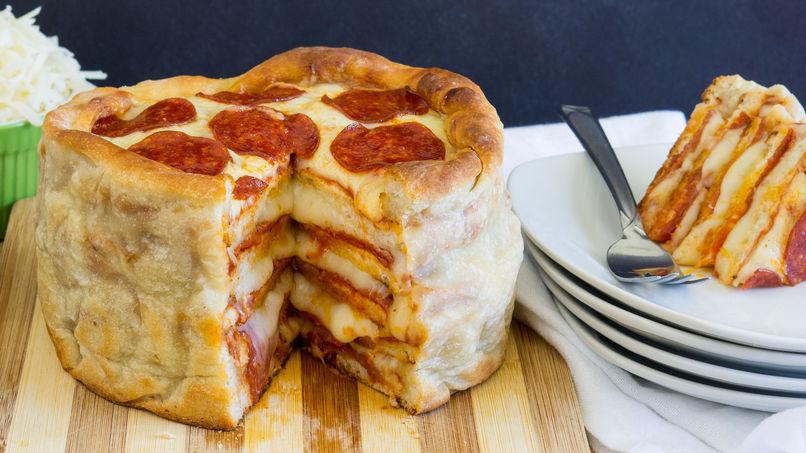 El pastel de pizza proviene de Canadá y se compone de muchas pizzas que se hornean en una olla para soportar las múltiples capas de pizza que pueden ser desde 3 hasta 6. 