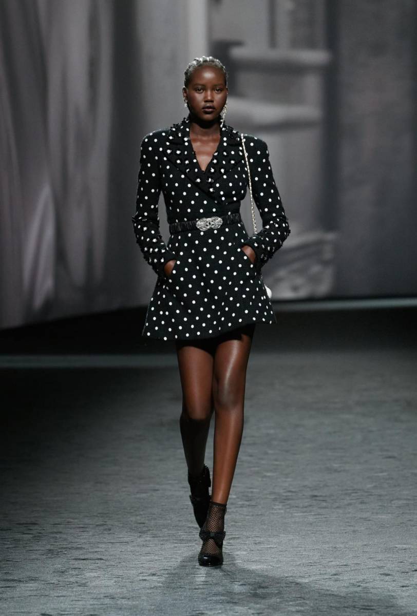 Lazos, boas, botas de pedrería, jersey trabajado a modo de escamas, tweeds pastel; polka dots... la colección Primavera-Verano 2023 Ready-To-Wear de CHANEL es un collage. Recreado por Virginie Viard como un paseo libre a través de fragmentos, expone un mundo imaginario enfrentado consigo mismo, ofreciendo variaciones sobre el tema del encanto.