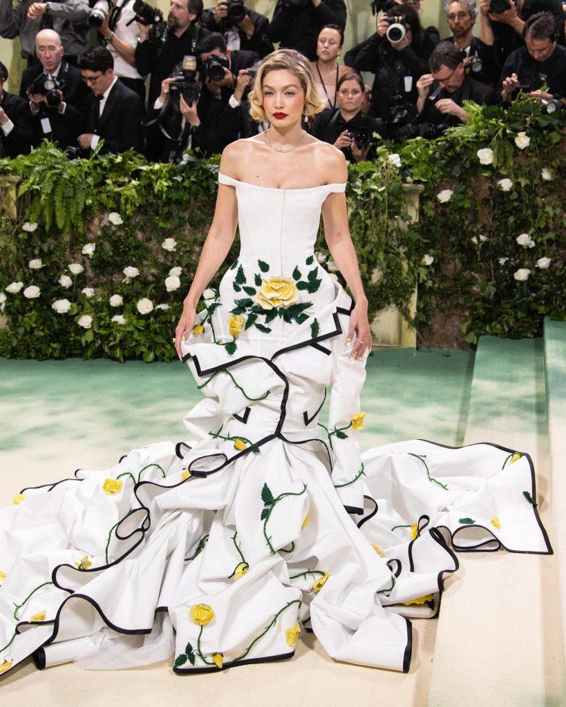 Gigi Hadid escogió un diseño de cuerpo encorsetado y falda muy voluminosa, que se realzaba con flores en relieve. Una propuesta de Thom Browne.