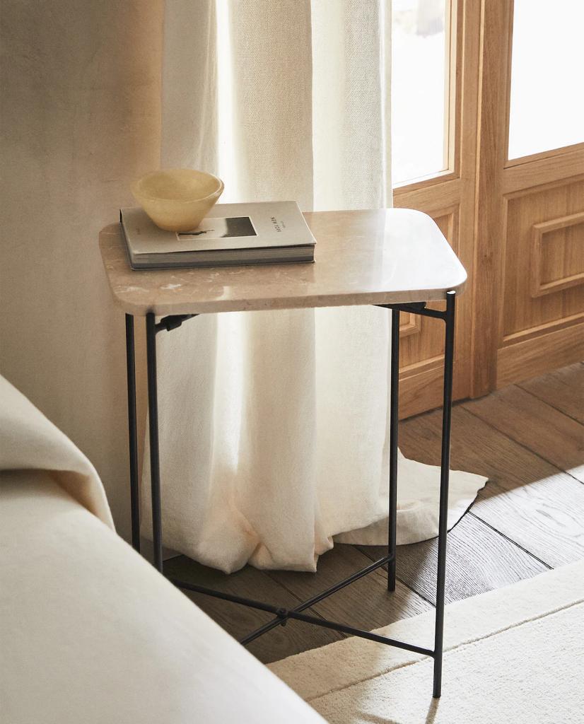 Mesa auxiliar de mármol con patas metálicas.