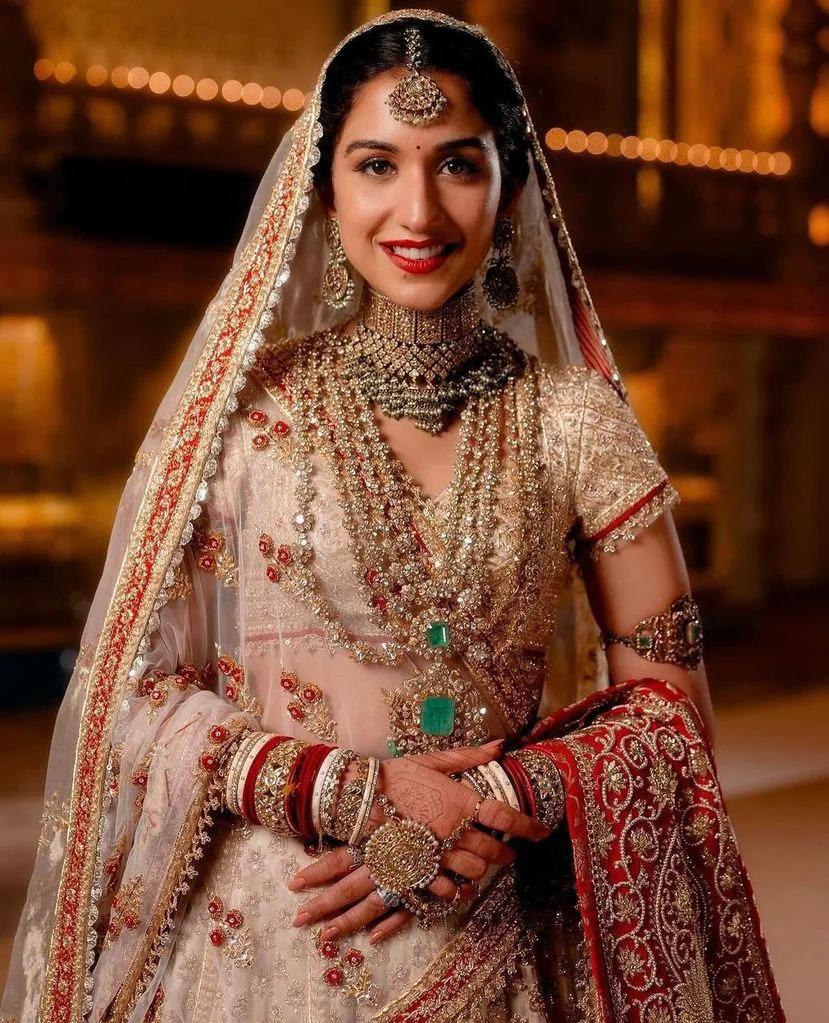 La novia, Rhadika Merchant, utilizó pendientes colgantes, múltiples collares y pulseras que adornaban sus muñecas. El collar utilizado es una reliquia familiar, ya que también fue utilizado por su hermana y tías. 