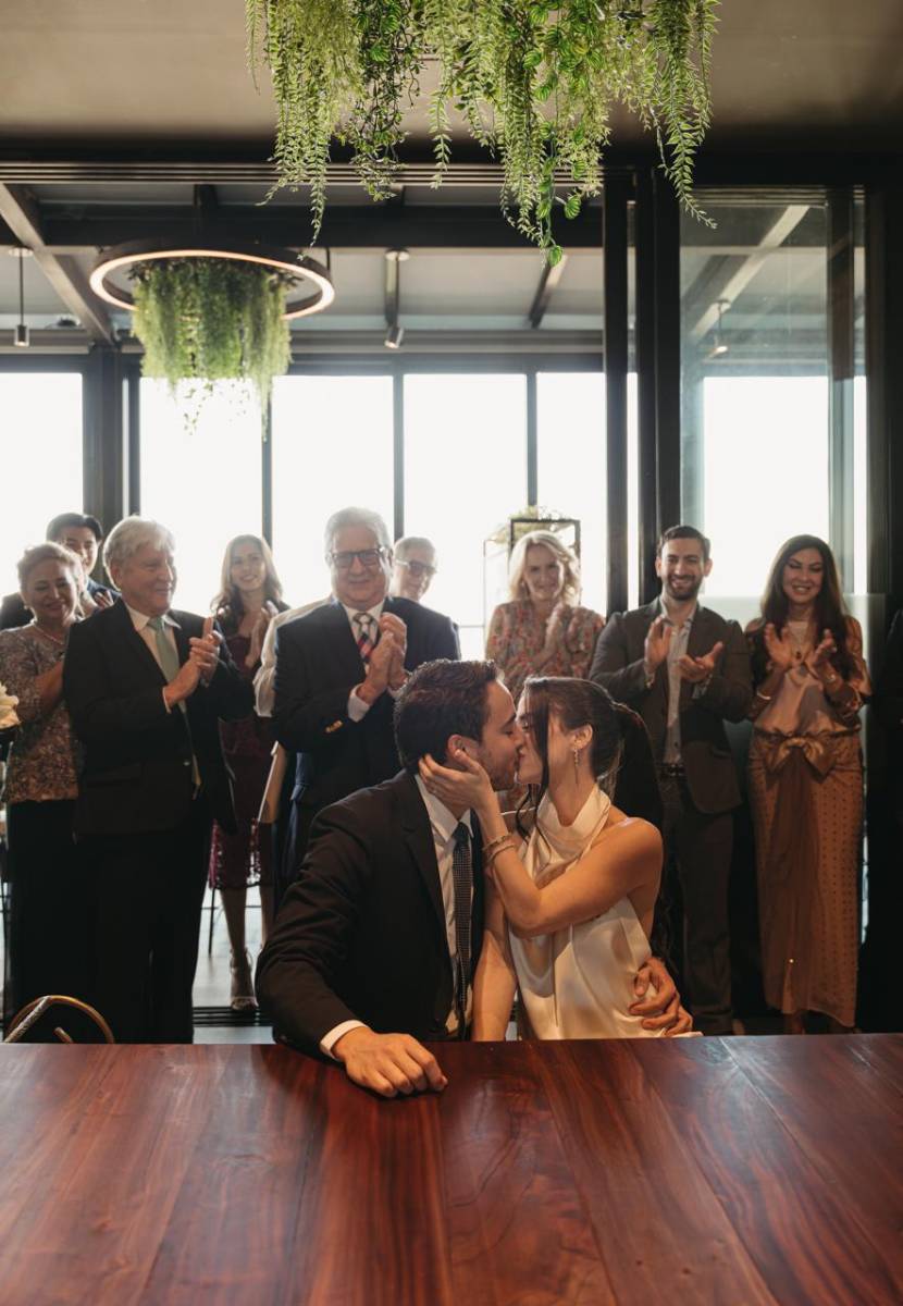 Los enamorados en un romántico beso luego de estampar sus firmas en el acta de matrimonio.