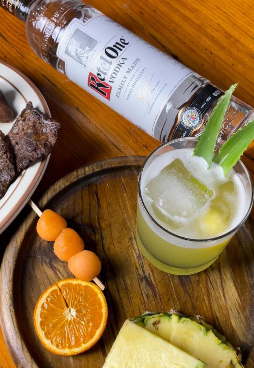 <b>Preparación </b>En una coctelera con hielo, agregamos los 3 Dash de angostura de naranja, vertemos nuestro vodka Ketel One y proseguimos a integrar, agregamos los ingredientes restantes y hielo, agítanos para integrar los sabores. Decoramos con esferas de Piña y hojas de Piña.