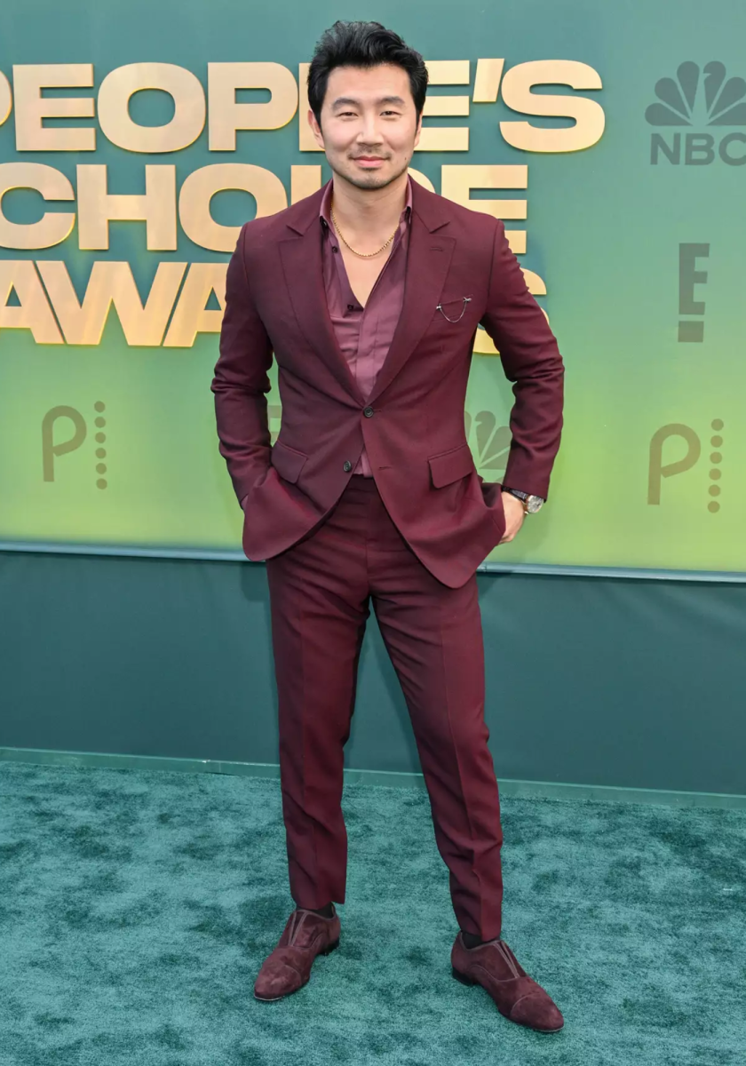 Simu Liu usó un traje merlot Berluti con camisa y zapatos a juego, combinándolo con un collar Fernando Jorge Sync y un reloj IWC Portugieser Perpetual Calendar.