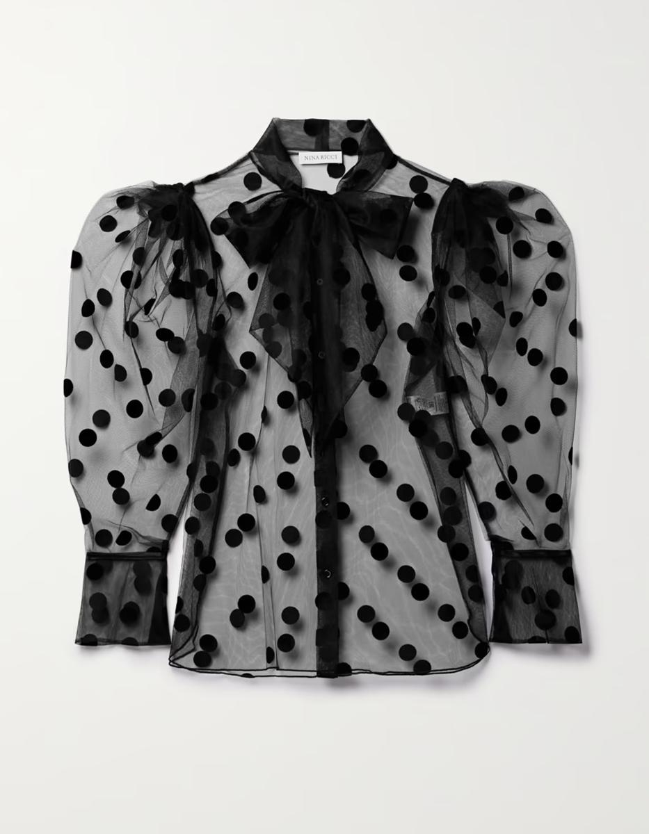 La blusa de Nina Ricci combina proporciones exageradas y texturas contrastantes. Está confeccionado en tul transparente con lunares táctiles y tiene mangas voluminosas para realzar aún más la forma holgada. 