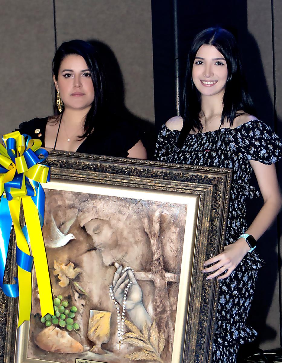 Joseline Midence e Isabella Interiano, sostienen la hermosa obra del reconocido pintor y maestro Antonio Vinciguerra.