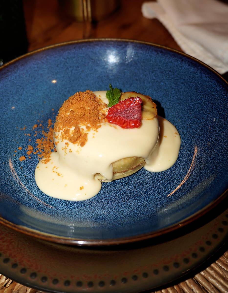 Panqueques con salsa cremosa de cheesecake, fusión de leches, galleta lotus y frutos rojos, coronados con banana caramelizada
