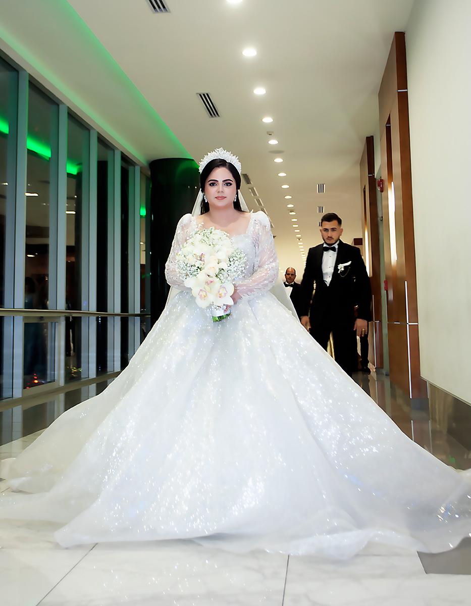 Andrea Nicole Carrillo Guzmán lució radiante en un vestido del diseñador turco Tarik Ediz con cola larga y con un velo hecho a mano con “One Love One Lifetime” escrito en perlas.