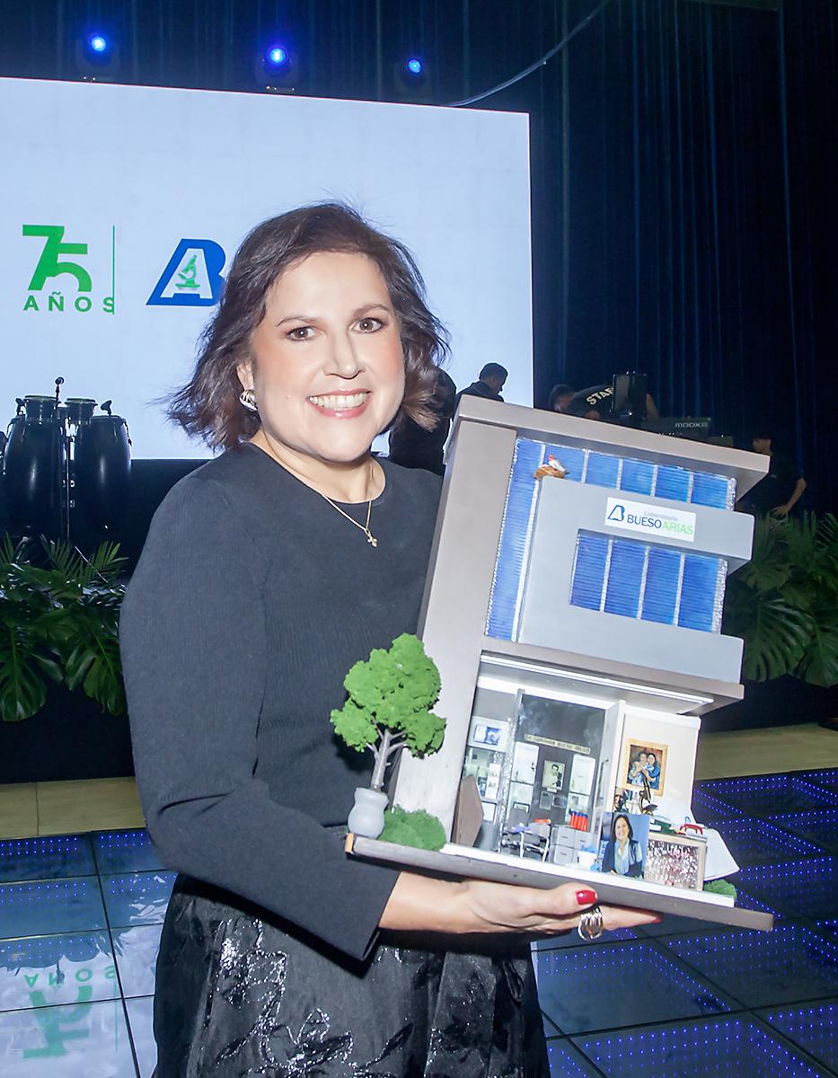 Ana Clemencia carga la réplica del edificio donde nació Laboratorio Bueso Arias en Barrio El Benque de San Pedro Sula.