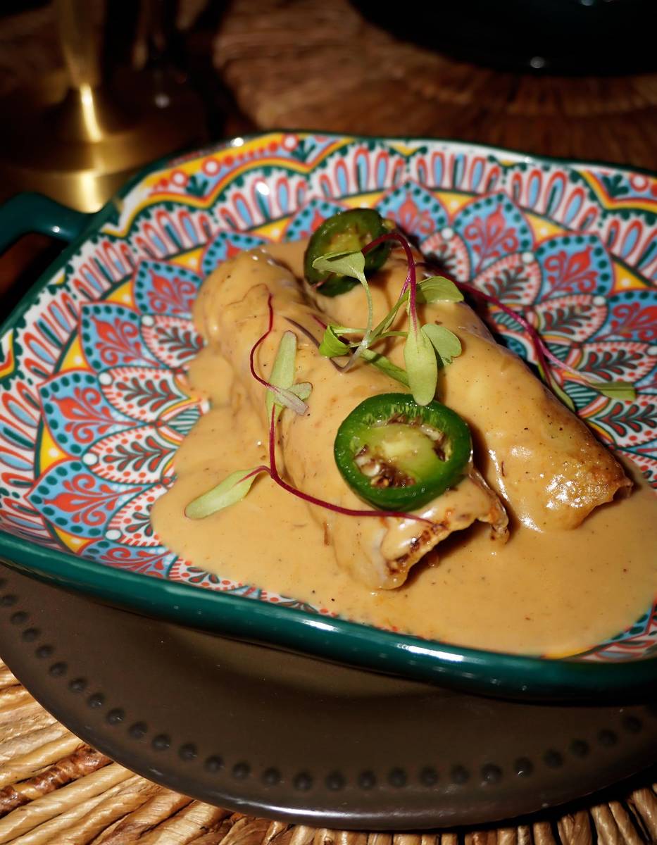 Enchiladas de brisket: tortillas de maíz rellenas de brisket ahumado, con fusión de quesos, bañadas con salsa cremosa de vino