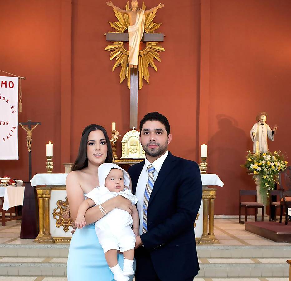 Daniela y Willy Alvarenga, con su hijo Daniel Emilio, durante la ceremonia de bautizo.