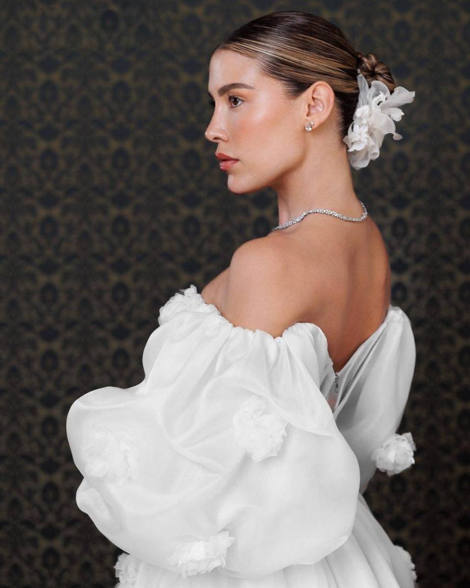 Michelle confiesa haber querido proyectar un toque más “romántico”. El segundo vestido presenta mangas 3/4 y está adornado con delicadas flores. Este también es de color blanco. La modelo explicó que buscaba un diseño mucho más sencillo que el vestido principal, pero siempre impactante. 