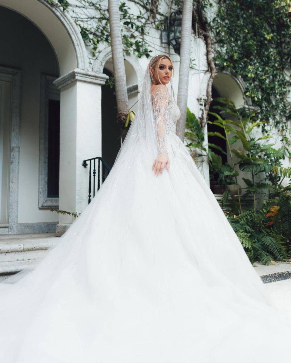 La venezolana lució un hermoso y elegante vestido del diseñador Zuhair Mura, con una parte superior tipo corsé, una voluminosa falda, con las mangas y corpiño llenos de piedras, cristales y lentejuelas, en colores bancos y plateados, y con un velo largo.