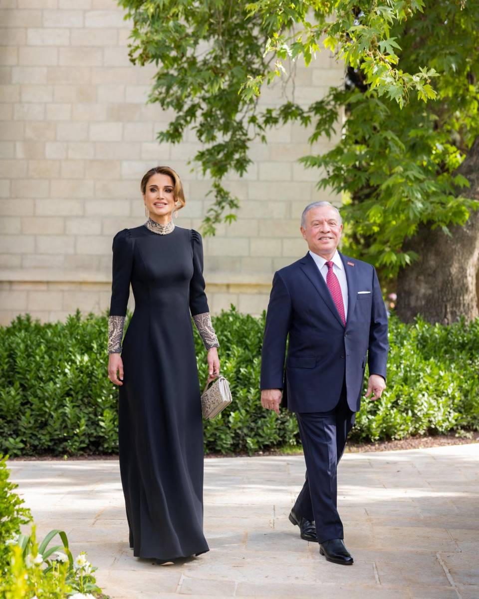 Los padres del novio, el rey Abdullah II y la reina Rania, vestida en un radiante diseño de Dior, a su llegada al Zahran Palace (Photo by Jordanian Royal Palace / AFP)