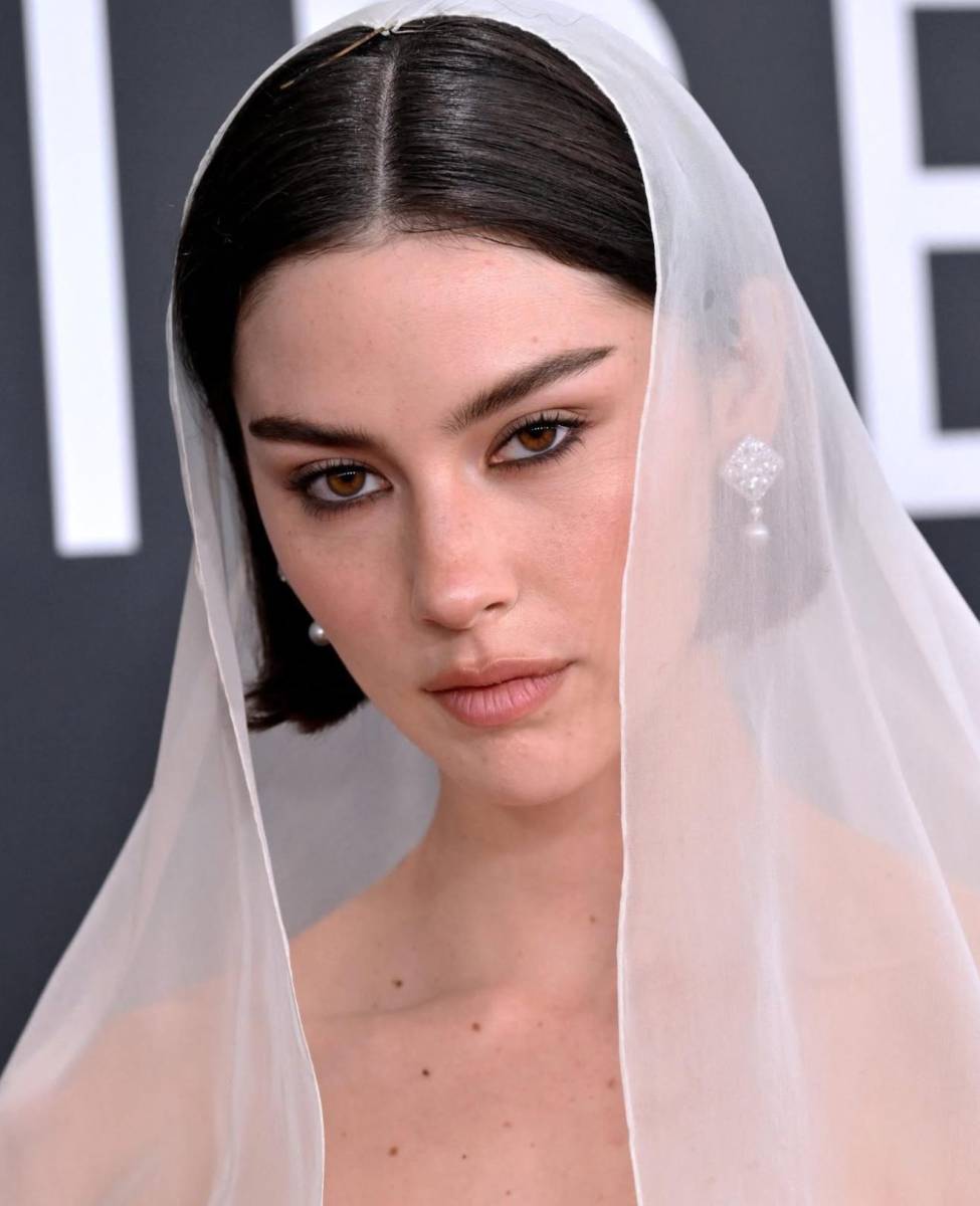 <b>Gracie Abrams</b> apostó por la sutileza y la naturalidad, destacando una piel luminosa y fresca. Las cejas definidas y los ojos ligeramente delineados en tonos marrones cálidos resaltaban la belleza natural, mientras los labios nude aportaban un toque delicado. El velo translúcido completó este look etéreo, demostrando que menos, es más.