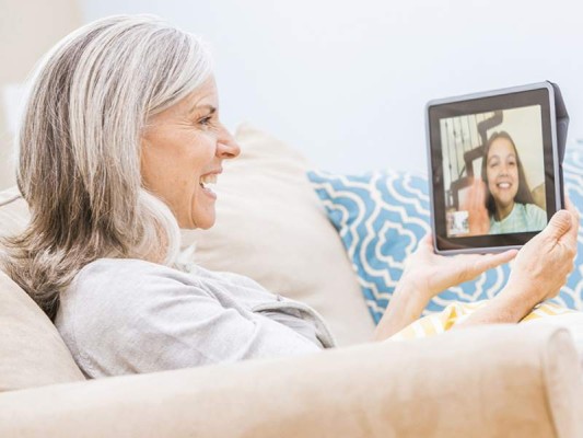 Caucasian grandmother videochatting with granddaughter on digital tablet $!Caucasian grandmother videochatting with granddaughter on digital tablet