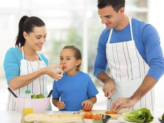 little girl tasting tomato while parents cooking $!little girl tasting tomato while parents cooking